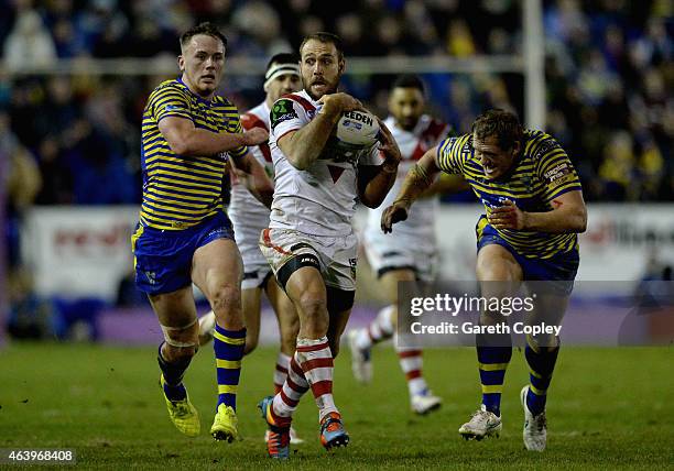 Jason Nightingale of St George Illawarra Dragons gets past Ben Currie and Ben Westwood of Warrington Wolves during the World Club Series match...