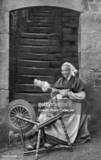 Woman at a spinning wheel, Dinan, Brittany, France, c1922. A print from Peoples of all Nations, Volume III, edited by JA Hammerton, The Fleetway...