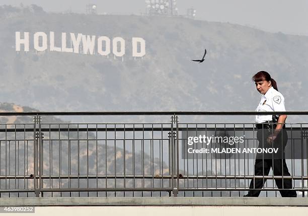 Security guard walks guarding on a shopping mall terrace outside Dolby Theatre as preparations are underway for the 87th annual Academy Awards in...