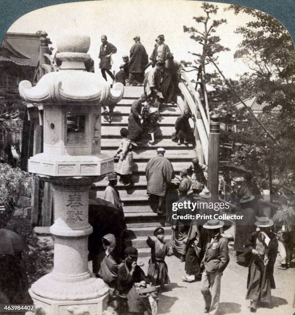 Worshippers crossing the semi-circular bridge to Kameido Temple beyond, looking north, Tokyo, Japan, 1904. A Shinto temple dedicated to Sugawara no...