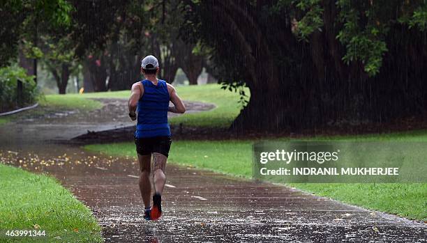 Man runs as rain caused by Tropical Cyclone Marcia falls in Brisbane on February 21, 2015. Australia was on February 21 assessing the damage from two...