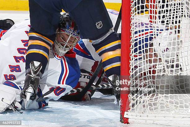 Mackenzie Skapski and Dan Girardi of the New York Rangers look for the puck during a scramble against the Buffalo Sabres on February 20, 2015 at the...