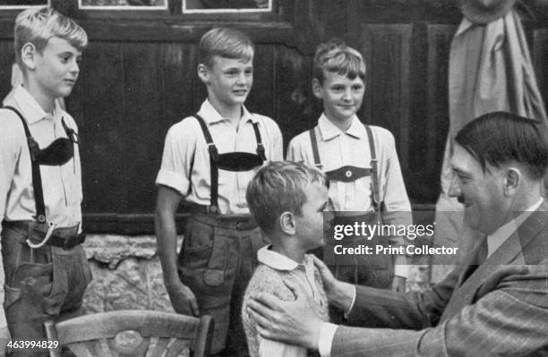 Four brothers meet Adolf Hitler, 1936. Hitler with four young boys dressed in traditional Bavarian costume. A print from Adolf Hitler. Bilder aus dem...