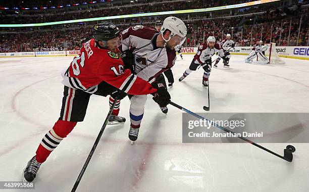 Marcus Kruger of the Chicago Blackhawks knocks the puck away from Jan Hejda of the Colorado Avalanche at the United Center on February 20, 2015 in...