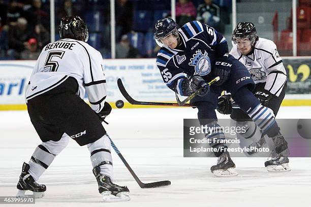 Nicolas Roy of the Chicoutimi Sagueneens shoots the puck deep as Elie Berube of the Gatineau Olympiques defends on February 20, 2015 at Robert...