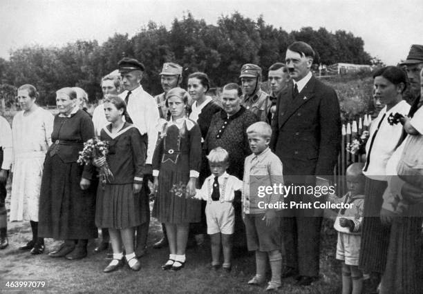 Adolf Hitler visiting a farming family in East Prussia, Germany, 1936. Hitler posing for a photograph with local people. A print from Adolf Hitler....