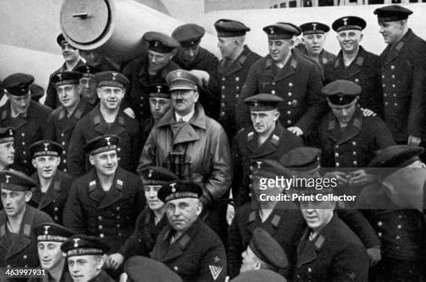 Adolf Hitler visiting a battleship, Germany, 1936. Hitler posing for a photograph with the crew. A print from Adolf Hitler. Bilder aus dem Leben des...