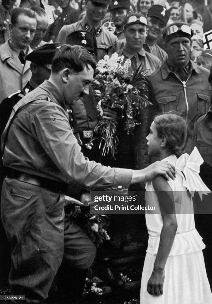Adolf Hitler talking with a young girl during his election campaign, 1932.