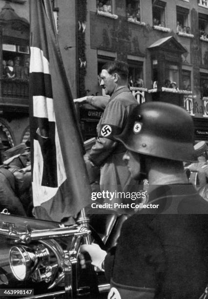 The Blood Flag of 1923, Nuremberg, Germany, 1936. Adolf Hitler in Nuremberg for the Nazi Party Congress, with a flag commemorating the failed Munich...