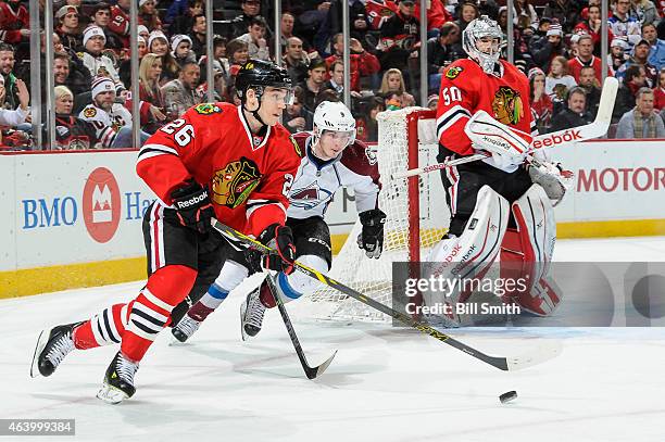 Kyle Cumiskey of the Chicago Blackhawks and Matt Duchene of the Colorado Avalanche chase the puck by goalie Corey Crawford during the NHL game at the...