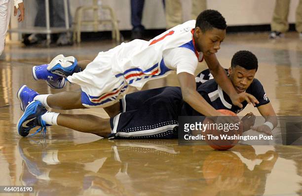 Sherwood's Chris West and Magruder's David Garey dive to the floor for a loose ball in the first half on February 20, 2015 in Olney, Md.