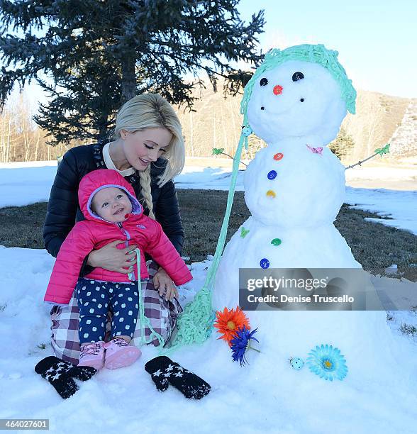 Holly Madison and Rainbow Aurora Rotella make a snowman during Sundance film festival on January 19, 2014 in Park City, Utah.