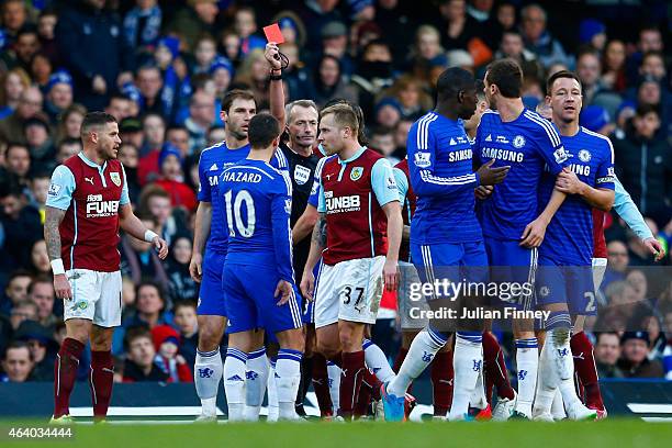 Referee Martin Atkinson shows the red card to Nemanja Matic of Chelsea for his reaction to the tackle by Ashley Barnes of Burnley during the Barclays...