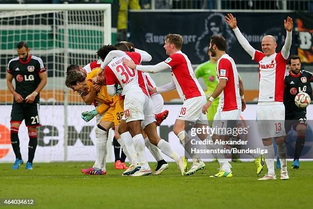 Marwin Hitz, keeper of Augsburg celebrates scoring the 2nd team goal with his team mates whilst Oemer Toprak of Leverkusen looks dejected during the...