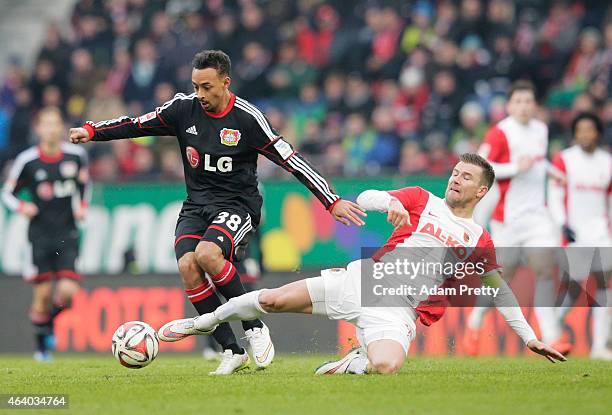 Karim Bellarbi of Bayer Leverkusen is challenged by Daniel Baier of FC Augsburg during the Bundesliga match between FC Augsburg and Bayer 04...