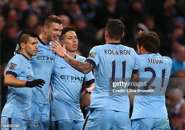 Edin Dzeko of Manchester City celebrates scoring their third goal with team mates during the Barclays Premier League match between Manchester City...