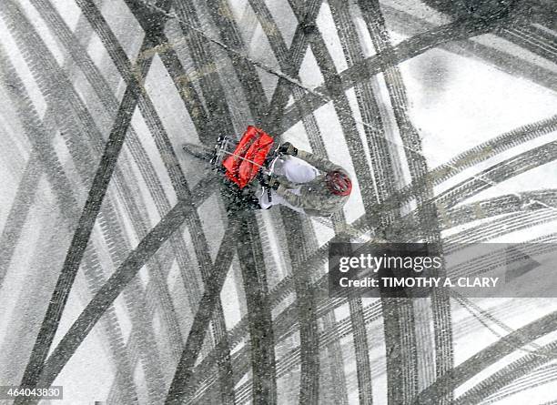 Pizza delivery man rides his bicycle through the snowy streets in Midtown Manhattan February 21, 2015 in New York. Accumulations of 1-2 inches are...