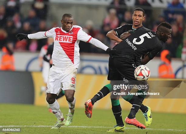 Anthony Ujah of Cologne tackles Salif Sane and Marcelo of Hannover during the Bundesliga match between 1. FC Koeln and Hannover 96 at...