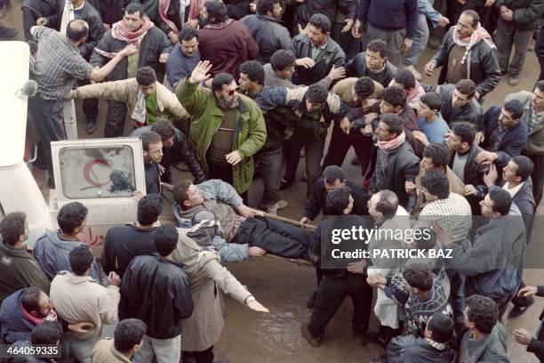 Palestinians evacuate an injured fellow on February 25 after the Cave of the Patriarchs massacre carried out by Jewish settler Baruch Goldstein, who...