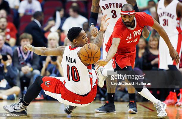 DeMar DeRozan of the Toronto Raptors and Corey Brewer of the Houston Rockets batlle for a loose basketball during their game at the Toyota Center on...