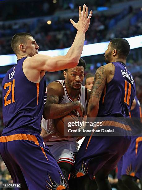 Derrick Rose of the Chicago Bulls tries to drive between Alex Len and Markieff Morris of the Phoenix Suns at the United Center on February 21, 2015...