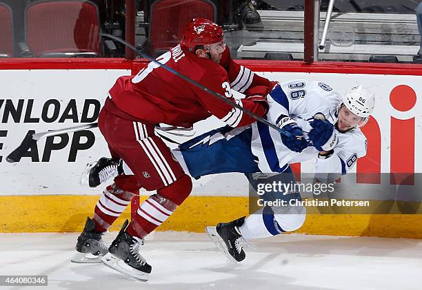 Keith Yandle of the Arizona Coyotes checks Nikita Kucherov of the Tampa Bay Lightning during the first period of the NHL game at Gila River Arena on...