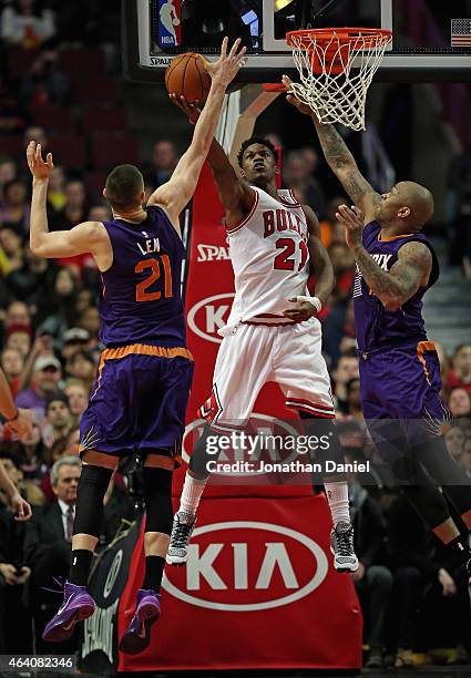 Jimmy Butler of the Chicago Bulls puts up a shot between Alex Len and P.J. Tucker of the Phoenix Suns at the United Center on February 21, 2015 in...