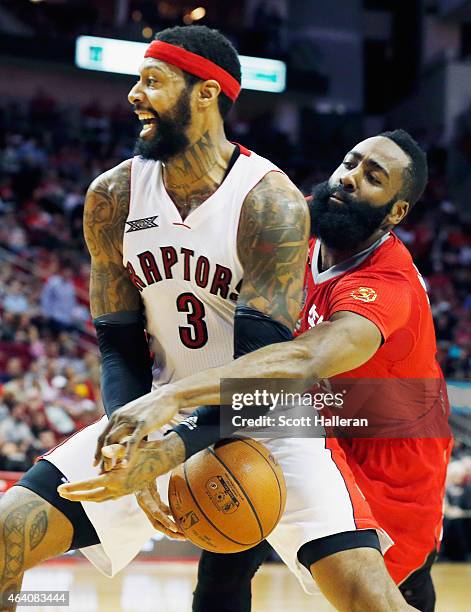 James Harden of the Houston Rockets reaches for the basketball behind James Johnson of the Toronto Raptors during their game at the Toyota Center on...