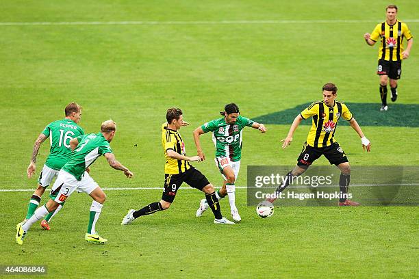 Zenon Caravella of the Jets attempts to beat the defence of Nathan Burns and Alex Rodriguez of the Phoenix during the round 18 A-League match between...