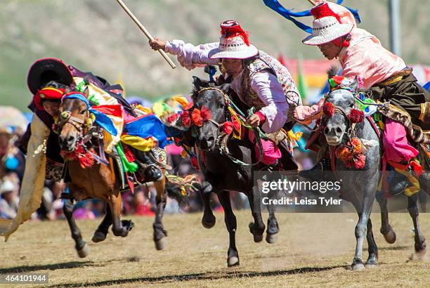 Khampa horseman practices picking up silk scarves from the back of a galloping horse at the Yushu Horse Racing Festival in Qinghai. Otherwise known...