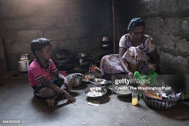 Sri Lankan refugee woman prepares lunch over an clay-stove in her one-room home provided by the Government of India.