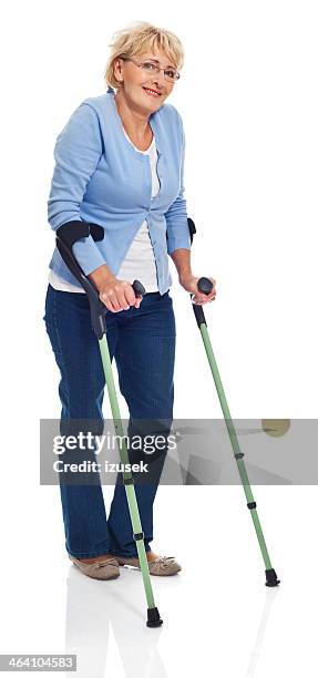 mujer madura con crutches - pierna fracturada fotografías e imágenes de stock