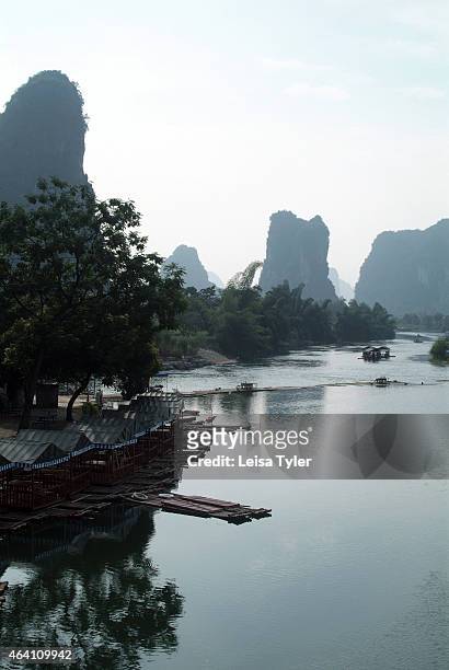 Bamboo rafts wait for passengers along the Yulong River in Yangshuo. Speckled with karst mountains and the gently flowing rivers, this region outside...