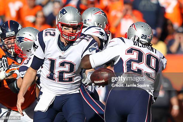 Tom Brady of the New England Patriots hands the ball to LeGarrette Blount against the Denver Broncos during the AFC Championship game at Sports...