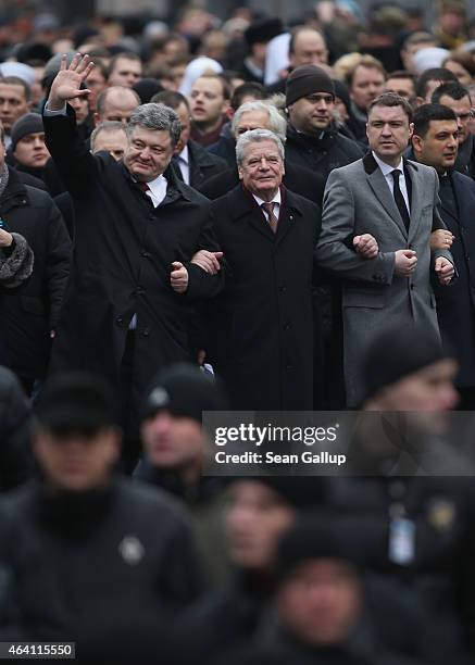Ukrainian President Petro Poroshenko waves as he walks arm in arm with German President Joachim Gauck in the "March of Diginity" prior to ceremonies...