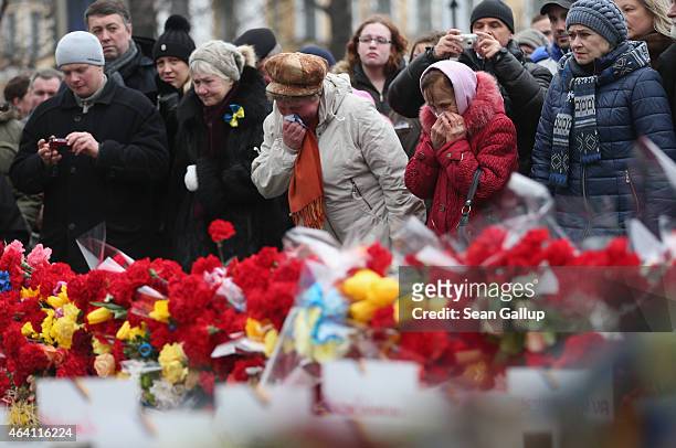 Women weep at a memorial to victims of the Maidan uprising prior to the "March of Diginity" and ceremonies marking the first anniversary of the...