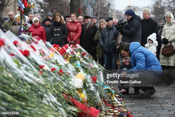 People lay flowers and candles at a memorial to victims of the Maidan uprising prior to the "March of Diginity" and ceremonies marking the first...