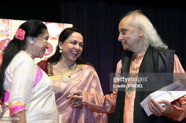 Indian Bollywood playback singer Asha Bhosle and actress Hema Malini speak with Indian classical vocalist Pandit Jasraj during a devotional album and...