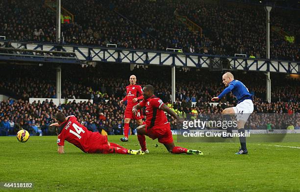 Steven Naismith of Everton shoots past Wes Morgan and Robert Huth of Leicester City to score their first goal during the Barclays Premier League...