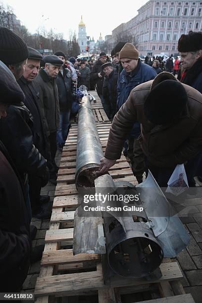 People look at the remains of a missile that is part of an exhibition of weapons, drones, documents and other materials the Ukrainian government...