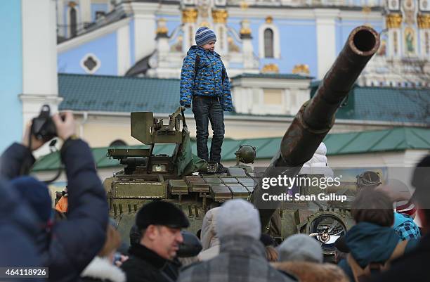 Child stands on top of a heavy tank that is part of an exhibition of weapons, drones, documents and other materials the Ukrainian government claims...