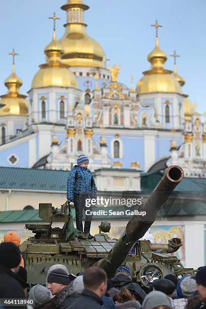 Child stands on top of a heavy tank that is part of an exhibition of weapons, drones, documents and other materials the Ukrainian government claims...
