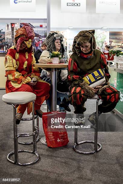 Women wear costumes as they sit at a table at the Gruene Woche agricultural trade fair on January 20, 2014 in Berlin, Germany. The Gruene Woche is...