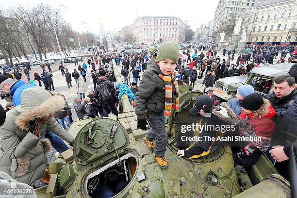 Children stand on top of a heavy tank that is part of an exhibition of weapons, drones, documents and other materials the Ukrainian government claims...