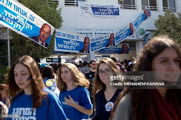 Israeli students of the Blich high school walk past Israeli Prime Minister Benjamin Netanyahu's election posters during a mock polling day in the...