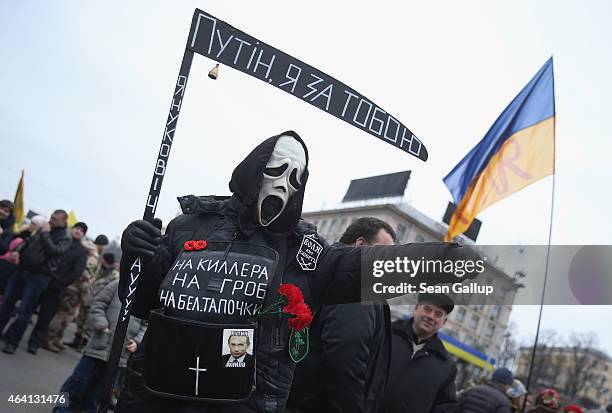 Someone wearing a death mask and holding a fake scythe with the inscription: "Putin, I'm coming to get you" walks amidst the crowd following...