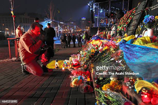 Thousands of people arrive to lay flowers and light candles at memorials to victims of the Maidan uprising one year ago following an evening ceremony...