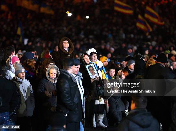 Thousands of people arrive to lay flowers and light candles at memorials to victims of the Maidan uprising one year ago following an evening ceremony...