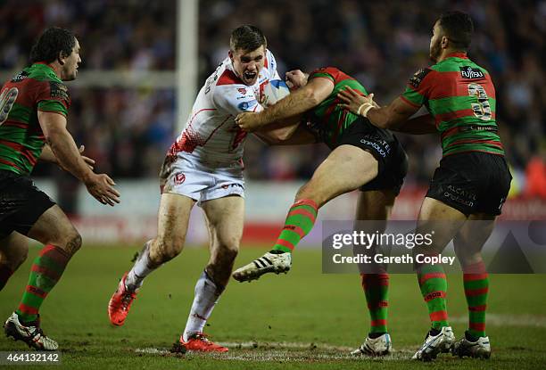 Joe Greenwood of St Helens is tackled by Glenn Stewart of South Sydney Rabbitohs during the World Club Challenge match between St Helens and South...