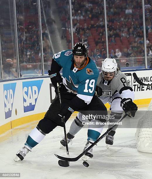 Joe Thornton of the San Jose Sharks carries the puck around Drew Doughty of the Los Angeles Kings during the 2015 Coors Light NHL Stadium Series game...